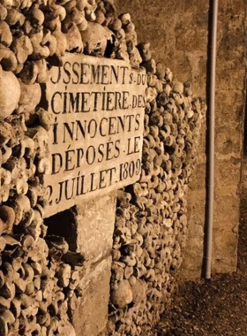 This image shows the eerie and fascinating Catacombs of Paris, an underground ossuary filled with the remains of millions of Parisians. The photo captures the neatly arranged bones and skulls, creating an unsettling yet historically significant atmosphere. The catacombs provide a glimpse into Paris' past, with their hauntingly artistic displays of bones and memorials. Visiting the catacombs offers a unique and somber look at the city’s history, making it a memorable, if slightly macabre, experience for curious travelers.