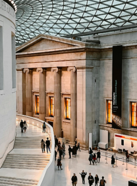 This image shows the grand interior of the British Museum, an iconic institution in London dedicated to human history, art, and culture. The museum houses millions of historical artifacts, including treasures from ancient Egypt, Greece, and Rome. The museum's central courtyard with its glass ceiling provides a beautiful setting for visitors to explore the many galleries. This museum is one of the world’s leading cultural institutions, offering free entry and a chance to discover diverse global histories.