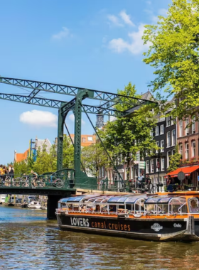 This image shows a scenic boat cruise gliding through Amsterdam's iconic canals, surrounded by charming 17th-century buildings, quaint houseboats, and iconic bridges. Visitors can enjoy a relaxing ride through the historic heart of Amsterdam. Some cruises even feature dinner or live commentary to enhance the experience, while private boat rentals offer a more personalized journey, allowing tourists to explore the city at their own pace. The calm waters and picturesque surroundings make it a must-do activity for those looking to experience Amsterdam from a different perspective.

