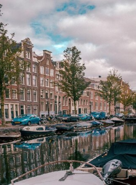 This image shows the charming Jordaan neighborhood in Amsterdam, with its narrow streets, picturesque canals, and boutique shops. Visitors can enjoy a relaxed stroll through the area, discovering art galleries, vintage stores, and cozy cafés. It’s a peaceful part of the city where you can sip a coffee and enjoy local delicacies like Dutch apple pie. Jordaan is perfect for those looking to explore a quieter, more intimate side of Amsterdam.