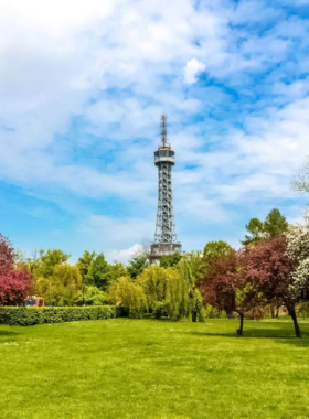 This image shows the Petrin Hill Lookout Tower in Prague, which offers a stunning panoramic view of the city. Resembling a miniature Eiffel Tower, the tower is situated on Petrin Hill, a peaceful park area perfect for hiking or picnicking. Visitors often climb the tower to take in breathtaking views of Prague’s skyline, including the Prague Castle and the Vltava River. The surrounding park is also a great place to relax and enjoy nature while taking in the stunning landscape."