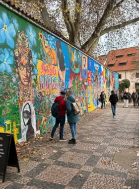 This image shows the Lennon Wall in Prague, a colorful and ever-changing piece of street art dedicated to John Lennon. The wall is filled with graffiti, peace messages, and symbolic artwork, reflecting the spirit of freedom and peace. It has become a popular spot for both locals and tourists to add their own messages or drawings. The wall is a symbol of Prague’s creative culture and the city’s history of political change, offering a reflective and artistic space for visitors to connect with the past and present.