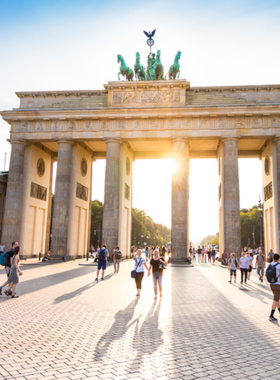 This image shows the iconic Brandenburg Gate, a symbol of Germany's unity and resilience, standing tall at Pariser Platz in Berlin. With its stunning neoclassical architecture, the gate has become one of the most recognizable landmarks in the city. Whether bathed in sunlight or illuminated at night, it reminds visitors of Berlin’s past struggles and hopeful future. The surrounding area offers a peaceful atmosphere where visitors can take in the beauty of this historic site.