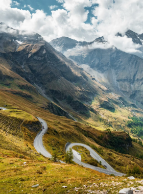 This image shows the Grossglockner High Alpine Road, one of Europe’s most scenic drives, winding through the Austrian Alps. The road offers stunning views of snow-capped peaks, lush meadows, and deep valleys. At the highest point, visitors can enjoy panoramic vistas of Grossglockner, Austria’s tallest peak. Whether driving or hiking, the road provides a spectacular journey through some of the most beautiful landscapes in Europe, making it a must-visit for adventure and nature enthusiasts.