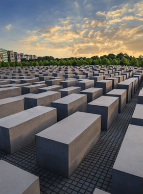 This image shows the solemn and powerful Holocaust Memorial in Berlin, consisting of over 2,700 concrete slabs arranged in a grid pattern. The memorial serves as a place of remembrance and reflection, commemorating the victims of the Holocaust. Its minimalist design creates a somber atmosphere that encourages visitors to reflect on the tragic past while educating future generations about the horrors of this dark chapter in history.