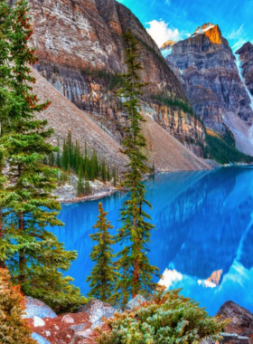 This image shows the breathtaking view of Banff National Park in Alberta, Canada. Towering snow-capped mountains rise above turquoise lakes, creating a stunning landscape. The park is famous for its natural beauty, offering hiking trails, wildlife sightings, and peaceful picnic spots. Visitors can see animals like elk, bears, and mountain goats while exploring. The crystal-clear water of Lake Louise and Moraine Lake reflects the surrounding peaks, making it a popular destination for photographers and nature lovers. The scenery changes throughout the seasons, from vibrant autumn colors to snowy winter landscapes.

