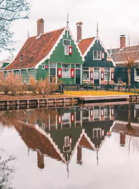 This image shows a traditional Dutch windmill at Zaanse Schans, a historic village near Amsterdam, known for its preserved windmills, wooden houses, and artisan workshops. The windmills, which were once used for industrial purposes like milling grain and sawing wood, are now iconic symbols of Dutch heritage. Visitors to Zaanse Schans can explore these fascinating structures and learn about the history of windmills in the Netherlands while enjoying the peaceful, rural landscape.