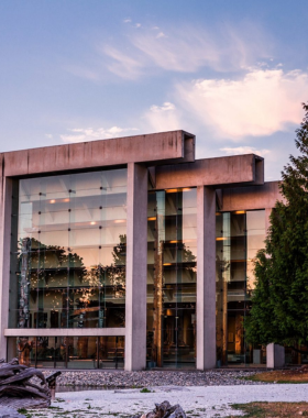 This image shows the Museum of Anthropology in Vancouver, displaying Indigenous art, historical artifacts, and cultural exhibits. Large wooden totem poles stand tall inside and outside the museum, showcasing intricate carvings. Visitors are admiring ancient artifacts, learning about First Nations history. The museum’s glass architecture allows natural light to illuminate the exhibits, creating an engaging and immersive experience. This spot is perfect for those interested in culture, history, and indigenous heritage.