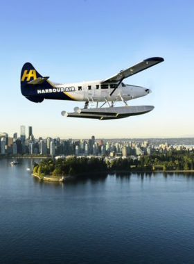 This image shows a seaplane soaring above Vancouver, offering a spectacular aerial view of the city, mountains, and ocean. The blue waters of the harbor stretch below, with downtown Vancouver’s skyline visible in the distance. Passengers are looking out of the windows, capturing stunning photographs. The experience offers a unique way to explore Vancouver’s beauty from above, making it a must-try adventure for visitors looking for a thrilling and unforgettable ride.