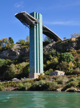 This image shows the Observation Tower at Niagara Falls, with visitors standing on the viewing deck and taking in the spectacular view of the falls. The mist rising from the water below creates a dramatic atmosphere, and the view from above offers a stunning panorama of the American and Canadian falls. This tower offers a fantastic vantage point for photography and a perfect spot to appreciate the falls from a higher perspective."