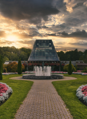 This image shows the lush, vibrant grounds of the Niagara Parks Botanical Gardens, where visitors stroll through beautiful flower beds, trees, and well-maintained walking paths. The colorful blooms and peaceful atmosphere make it an ideal location for nature lovers. The garden is filled with a variety of plant species, offering a relaxing and scenic environment that contrasts beautifully with the nearby Niagara Falls.