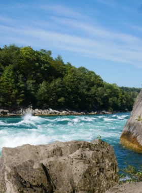 This image shows a group of hikers walking along the Niagara Gorge Trail, surrounded by lush greenery and scenic views of the Niagara River. The trail offers a great way to explore the area’s natural beauty, with cliffs and rapids creating a stunning backdrop. Hikers can be seen pausing at various lookout points to take in the spectacular views of the gorge and the rushing waters below. It’s a perfect activity for nature lovers and adventure seekers."