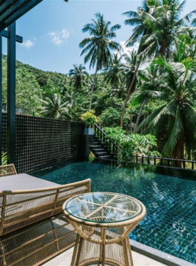 This image shows The Tarna Align Resort, a luxurious eco-resort perched on a hilltop with sweeping views of Koh Tao’s coastline. The resort features an infinity pool, a relaxing spa, gourmet dining, and yoga sessions, blending luxury with sustainability.