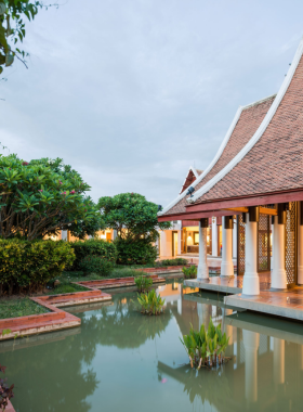  This image shows Sukhothai Heritage Resort, showcasing traditional Thai architecture surrounded by lush greenery. The resort offers a tranquil atmosphere with luxury rooms, a full-service spa, and a relaxing pool area, perfect for a peaceful getaway.