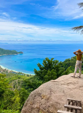 This image shows Mango Viewpoint, a scenic hilltop spot in Koh Tao that offers breathtaking views of the island. The short hike to the viewpoint is surrounded by lush greenery, leading to a panoramic vista of the ocean and coastline. It is a perfect spot for relaxing and capturing stunning photographs.