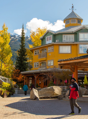 This image shows the lively atmosphere of Whistler Village, a charming pedestrian-only area filled with shops, restaurants, and cafes. People stroll through the streets, enjoying the cozy alpine architecture. Outdoor seating areas invite visitors to relax and soak in the lively surroundings. The vibrant storefronts and twinkling string lights add to the welcoming ambiance, making it a perfect place to unwind after a day of adventure. This image beautifully captures the heart of Whistler's social and cultural life.