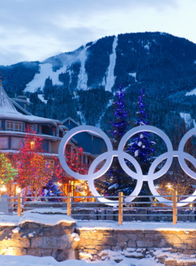 This image shows Whistler Olympic Park, covered in snow, with skiers and snowboarders enjoying the Olympic-level facilities. The large ski jump towers stand tall against the bright blue sky, representing the legacy of the 2010 Winter Olympics. People are cross-country skiing along well-groomed trails, surrounded by scenic mountain views. This image highlights the excitement of winter sports in Whistler Olympic Park, a must-visit spot for anyone who loves outdoor adventures.