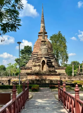 This image shows visitors walking around the impressive Wat Mahathat temple in Sukhothai Historical Park, surrounded by ancient ruins and lush greenery, offering a glimpse into the region’s rich past.