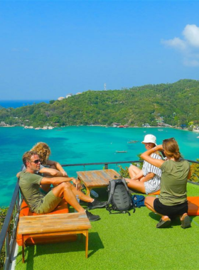 This image shows the panoramic view from Sun Suwan 360 Bar in Koh Tao, Thailand, highlighting the stunning sunset over the island's coastline. The bar's relaxed ambiance and scenic surroundings make it a perfect spot for capturing breathtaking evening views.