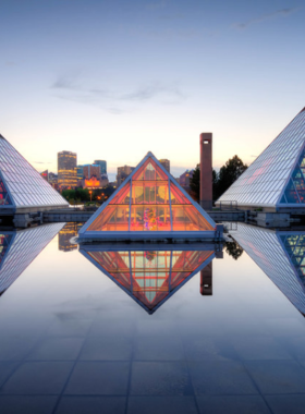 This image shows the stunning glass pyramids of Muttart Conservatory in Edmonton, a beautiful indoor botanical garden. Each pyramid houses different ecosystems, including a tropical rainforest, desert landscapes, and arid zones. It is a peaceful and immersive experience for plant lovers, offering a chance to explore diverse plant species. The serene environment provides a relaxing getaway for those who enjoy nature and are fascinated by plant life."