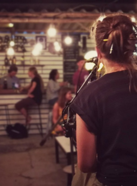 This image shows the lively and welcoming atmosphere of Good Vibe Bar in Koh Tao, with guests dancing, singing, and enjoying the vibrant playlist. The colorful interior and friendly crowd make it a popular nightlife spot.