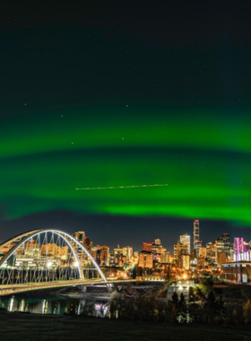 This image shows the spectacular Northern Lights, or Aurora Borealis, lighting up the night sky near Edmonton, Alberta. The colorful lights are a natural phenomenon that occur in the Arctic and boreal regions. Edmonton’s clear skies and low light pollution make it an ideal location to witness this beautiful display. Visitors gather at designated viewing areas to experience the vibrant greens, reds, and purples that dance across the sky during optimal aurora activity."