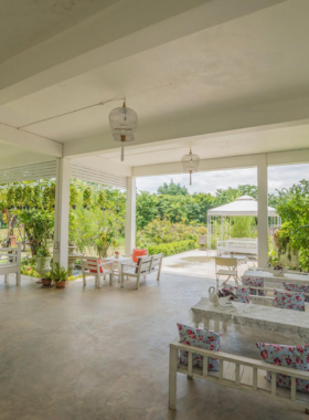 This image shows the Sweet Rice Cafe with its outdoor garden setting, where tables are surrounded by greenery and flowers. The table displays fried rice and other signature dishes, presented with a touch of elegance. The cozy and charming ambiance, combined with scenic views, makes this cafe a peaceful retreat for enjoying delicious food and desserts in Sukhothai.