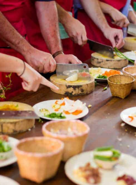 This image shows a group of people learning to cook traditional Thai dishes during a cooking class in Koh Tao. Participants are guided by local chefs to prepare popular dishes like Pad Thai and green curry, providing an authentic cultural experience and hands-on cooking skills.