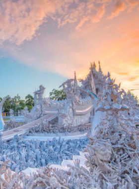 This image shows the magnificent White Temple in Chiang Rai, Thailand, with its intricate white carvings and beautiful architecture. It represents purity and enlightenment, blending traditional Thai and contemporary styles, offering a peaceful and spiritual atmosphere for visitors to explore.