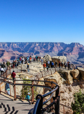 This image shows the stunning sunrise at Mather Point in the Grand Canyon, with soft golden light illuminating the vast canyon walls. The early morning light creates an amazing view, with vibrant colors spreading across the landscape, perfect for photography enthusiasts and those looking to enjoy the peaceful atmosphere of the canyon during the first light of day. Visitors can enjoy the breathtaking sight of the canyon while experiencing a calm and serene start to the day.