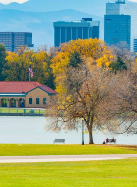 This image shows City Park, a large and scenic urban park in Denver, offering expansive green lawns and peaceful walking paths surrounded by trees. The park provides a relaxing atmosphere, with locals jogging, walking their dogs, and enjoying the fresh air. In the background, visitors can see picturesque views of the Denver skyline and nearby mountains. Whether for a leisurely stroll, a picnic, or visiting the nearby Denver Zoo, City Park offers plenty of outdoor activities for all ages.