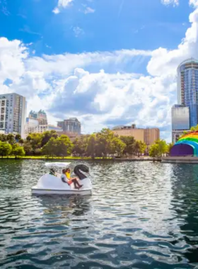 This image shows Lake Eola Park, a tranquil urban park in downtown Orlando, offering visitors a peaceful space to relax by the water. The park features swan-shaped paddle boats, green areas for picnics, and walking paths around the lake. Visitors can unwind while enjoying the beautiful natural surroundings, making it an ideal spot for a leisurely afternoon stroll or a relaxing moment away from the city’s hustle.