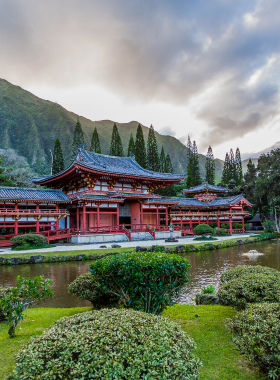 This image shows that the Byodo-In Temple, located in the Valley of the Temples, is a beautiful Buddhist temple built to commemorate the 100th anniversary of Japanese immigrants to Hawaii. Modeled after a 900-year-old temple in Japan, it’s known for its peaceful atmosphere, stunning architecture, and serene pond filled with koi. The temple provides a tranquil setting for reflection and spiritual connection, surrounded by lush greenery and majestic mountain views.