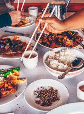 A selection of Chicago’s iconic foods, including an Italian beef sandwich, a Chicago-style hot dog, and Garrett’s caramel and cheese popcorn.