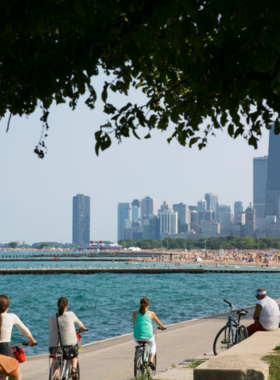 Cyclists and joggers enjoying a scenic ride along Chicago’s Lakefront Trail with the city skyline in the background.