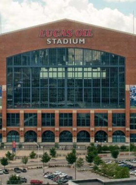 This image shows the massive Lucas Oil Stadium in Indianapolis, home to the Indianapolis Colts NFL team. The stadium features a retractable roof and state-of-the-art facilities, providing a perfect environment for both sports events and concerts. The vibrant crowd can be seen enjoying the excitement of a football game, with the field and players in action. Lucas Oil Stadium is also known for its exceptional acoustics and has hosted numerous major events, making it a hub of entertainment and sports in the heart of Indianapolis.