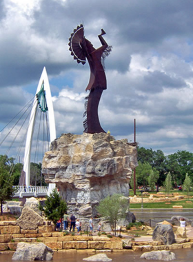 This image shows the Keeper of the Plains Plaza, a beautiful and tranquil public space in Wichita, Kansas. Featuring the iconic Keeper of the Plains statue, this plaza is a symbol of Wichita’s Native American heritage. At night, fire pots around the statue create a magical atmosphere. Visitors can relax and enjoy stunning views of the river and surrounding area. The plaza is a peaceful place for reflection, learning, and enjoying Wichita's natural beauty.