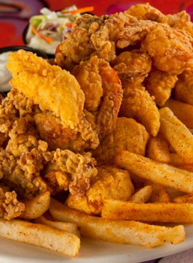 This image shows a plate of authentic Creole and Cajun food, including gumbo, jambalaya, po’boys, and crawfish, served at a local New Orleans restaurant. Creole and Cajun cuisine is rich in flavor, influenced by French, African, and Native American cultures. Known for its bold spices and fresh seafood, this unique culinary style offers a delicious experience of New Orleans’ heritage.