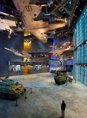 This image shows an exhibit inside the National WWII Museum in New Orleans, showcasing artifacts, photographs, and personal stories of those who lived through the war. The museum provides a deep dive into the history of World War II, covering various aspects from the battlefront to the homefront, offering visitors a detailed and immersive experience of this pivotal moment in history.