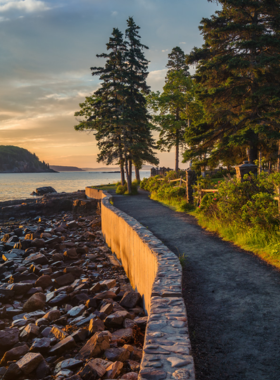 This image shows a peaceful and scenic walk along the Shore Path, a 1.4-mile trail stretching along the coastline of Bar Harbor. The path offers stunning views of Frenchman Bay, the Porcupine Islands, and the distant lighthouses. Perfect for a leisurely stroll, it’s an easy walk for people of all ages, and visitors might spot seals or even a bald eagle during their peaceful journey.