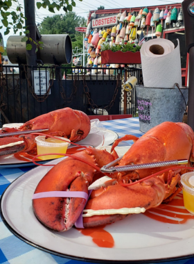 This image shows a freshly cooked lobster meal, complete with a whole lobster, lobster roll, and creamy lobster bisque, served at Thurston’s Lobster Pound in Bar Harbor. A true Maine experience, lobster is a must-try when visiting the region. The vibrant red lobster served with a side of butter captures the essence of the local culinary tradition, offering visitors a taste of the fresh and delicious seafood of the area.