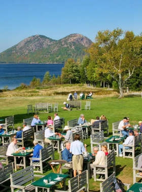 This image shows the peaceful Jordan Pond in Acadia National Park, with the iconic Bubbles Mountains reflected in the calm water. Visitors can relax at the Jordan Pond House and enjoy the famous popovers, a warm, fluffy pastry served with butter and jam. The serene setting, combined with delicious food, makes it an unforgettable stop for those exploring Acadia’s natural beauty.