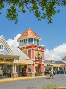 This image shows shoppers browsing through the stores at the Tanger Outlets in Ocean City. The outlet mall features a variety of shops offering clothing, accessories, electronics, and more at discounted prices. The open-air layout of the shopping center invites visitors to explore the stores while enjoying the fresh air. The Tanger Outlets are a popular destination for both locals and tourists looking for great deals and a wide range of high-quality brand-name products.