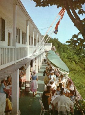 This image shows guests enjoying afternoon tea at the historic Tea Room at the Grand Hotel on Mackinac Island. The Grand Hotel has been offering luxurious afternoon tea since 1887, providing visitors with an elegant setting to relax and indulge in delicious tea blends, finger sandwiches, scones, and pastries. The Tea Room offers stunning views of the island’s gardens and Lake Huron, making it the perfect spot for a leisurely and refined experience.