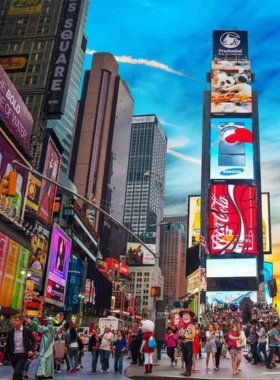 This image shows the electric energy of Times Square at night, with massive LED billboards displaying advertisements, Broadway shows, and digital art. A crowd of people from all over the world walks along the busy streets, taking in the dazzling lights and bustling atmosphere. Yellow taxis move through the roads, and street performers entertain visitors. The endless vibrancy of this famous intersection makes it a must-visit in New York City.