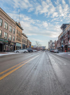 This image shows Downtown Fargo, a vibrant and lively area with historic brick buildings, street art, unique shops, and busy sidewalks. Pedestrians are walking along the streets, enjoying the local boutiques, coffee shops, and restaurants. The Fargo Theatre’s neon sign glows brightly in the background, adding a nostalgic feel. The scene captures the city’s mix of old and new, making it a must-visit spot for shopping, sightseeing, and experiencing Fargo’s urban charm.