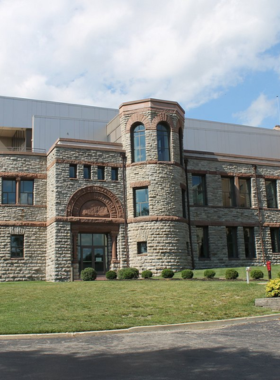 This image shows the Cincinnati Art Museum, a grand building surrounded by greenery in Eden Park. The museum’s elegant architecture features large columns and a beautiful entrance. Inside, visitors admire diverse art collections, including Renaissance paintings, modern masterpieces, and historic sculptures. A person is seen gazing at a famous painting, while others explore different galleries. The museum offers a peaceful atmosphere for art lovers to immerse themselves in creativity and culture. The free admission makes it an accessible and popular destination for those looking to experience world-class art without any cost.