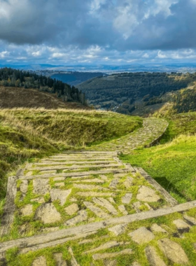 This image shows the panoramic view from Twmbarlwm Hillfort, an ancient fort sitting high above Newport. The hill is covered in grassy slopes, and the hiking trail winds through woodlands and open landscapes. On a clear day, visitors can see the city, countryside, and coastline stretching for miles. The climb is challenging but rewarding, offering fresh air, stunning scenery, and a glimpse into Newport’s ancient history.