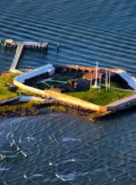 This image shows Fort Sumter National Monument in Charleston, a historic site where the first shots of the Civil War were fired. The image captures the fort’s brick walls and cannons against a backdrop of the serene harbor. Visitors can explore the fort and learn about its pivotal role in American history, particularly during the Civil War. The photo also features a boat arriving at the island, where visitors can take guided tours to discover more about this important landmark.