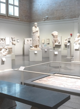 This image shows a stunning exhibit inside the San Antonio Museum of Art, featuring sculptures, paintings, and ancient artifacts from around the world. Visitors are seen admiring the diverse collection, which includes Egyptian relics, Latin American folk art, and contemporary masterpieces. The museum's grand interior, housed in a historic brewery building, adds to the cultural richness and artistic charm of the experience.